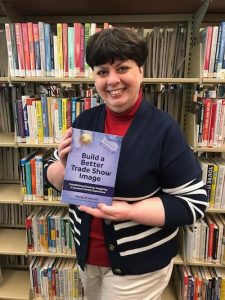 Marlys Arnold holding her book, Build a Better Trade Show Image